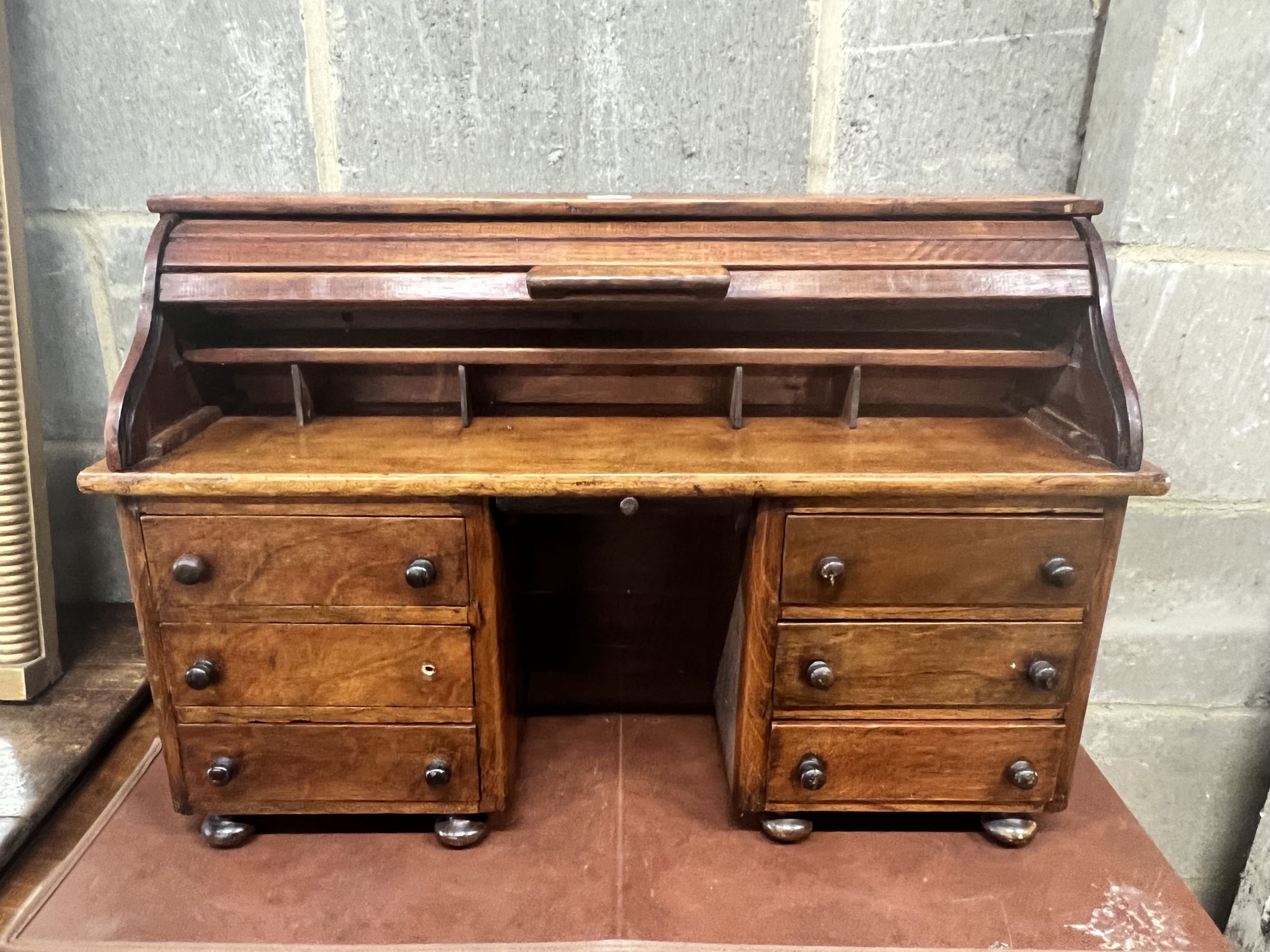 A miniature mahogany and hardwood kneehole tambour desk, width 69cm, depth 22cm, height 45cm.